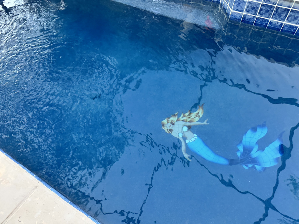 Custom mermaid mosaic tile installed on a pool floor during a resurfacing renovation