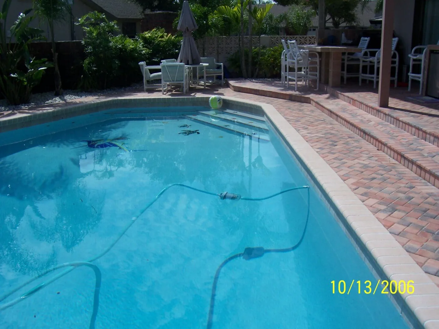 Outdoor Living — brick paver patio with poolside bar seating and tropical landscaping by Pool Builder of Brevard